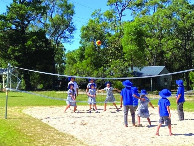 Hillside students playing beach volleyball on the volleyball court.