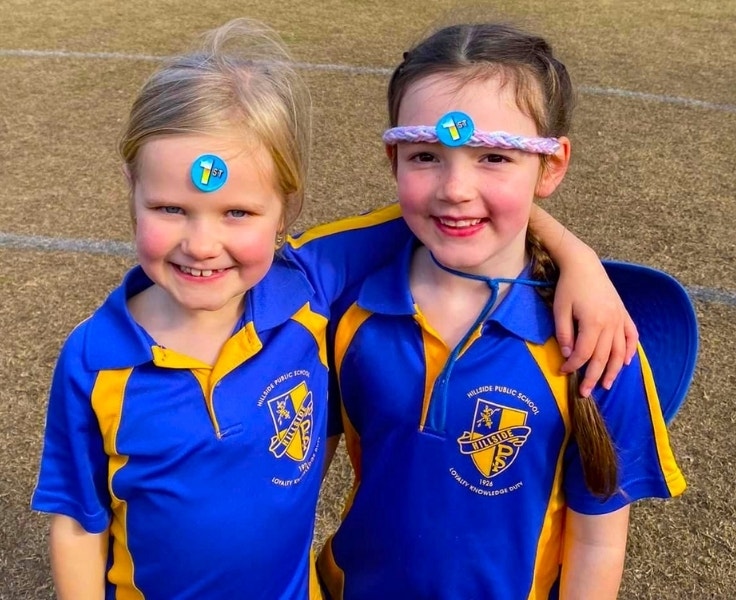 Hillside students hugging and smiling together on the grass during the Premier’s Sporting Challenge