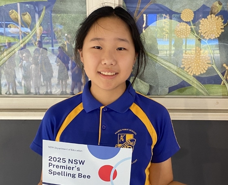 Hillside student handing a Premier's spelling bee certificate.