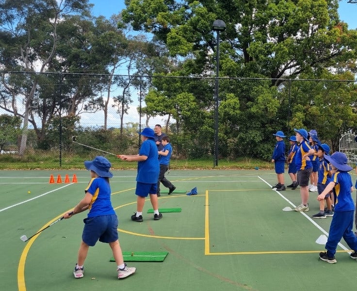 Hillside students participating in golf lessons on the basketball court
