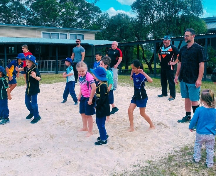 Hillside students and their dads playing beach volleyball on the volleyball court