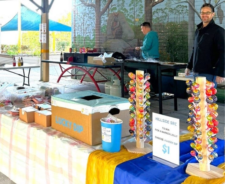 Parents cooking barbeque and selling items for election day.