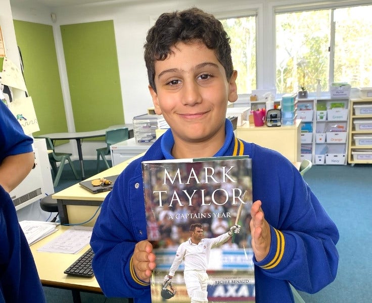 Hillside student holding a book in his classroom