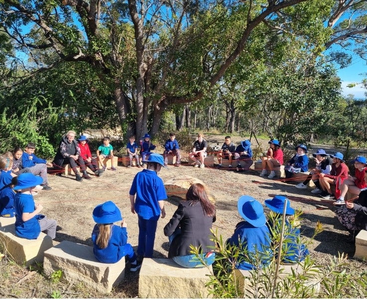 Hillside students sitting in the yarning circle with teachers.