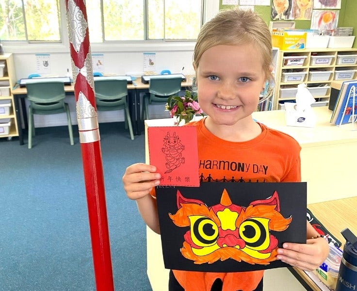 Hillside student holding harmony day artwork