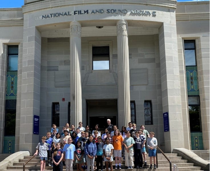 Year 5 and 6 students standing in front of National film and sound archive whilst on camp in Canberra.